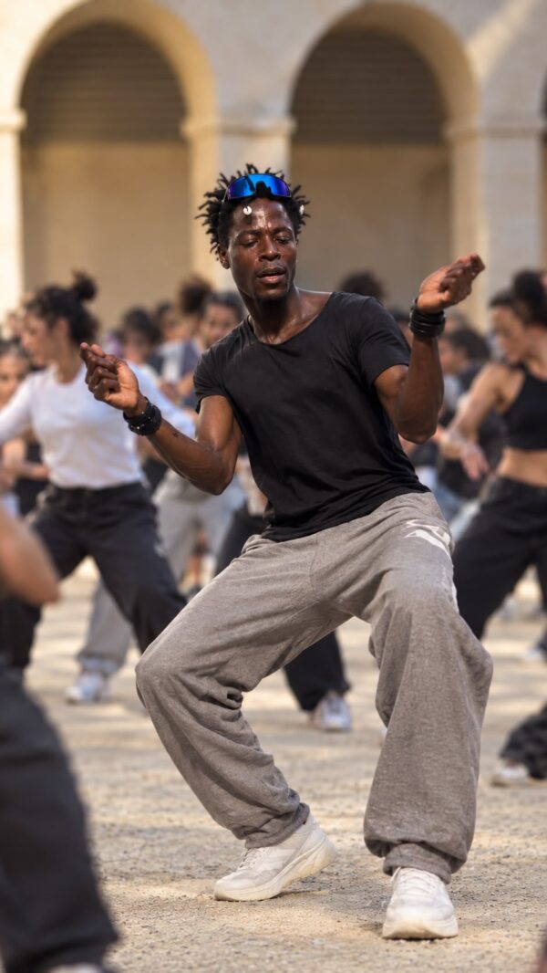 Siaka Coulibaly dansant devant un groupe en plein air